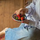 Fresh strawberries served in a ceramic bowl, capturing a simple and healthy lifestyle moment in a rustic countryside setting.