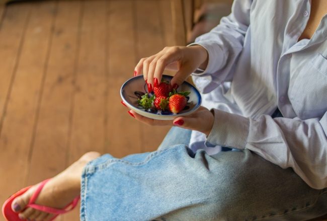Fresh strawberries served in a ceramic bowl, capturing a simple and healthy lifestyle moment in a rustic countryside setting.