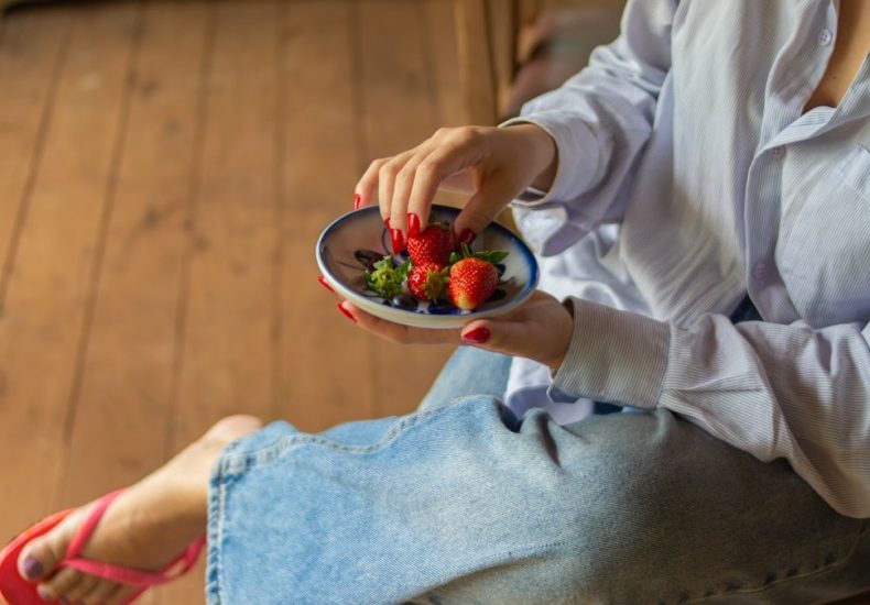 Fresh strawberries served in a ceramic bowl, capturing a simple and healthy lifestyle moment in a rustic countryside setting.