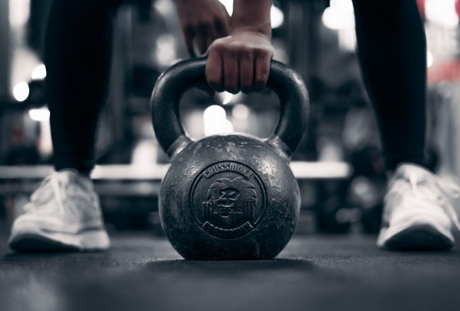 a person holding a kettle in a gym