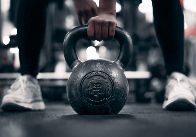 a person holding a kettle in a gym